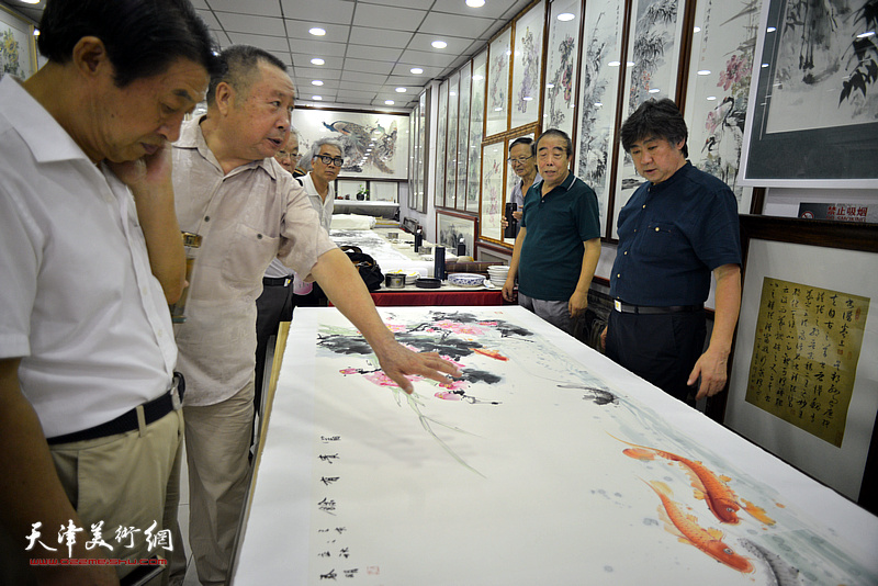 贾春明、武子明、李兆河在鹤艺轩合作巨幅花鸟画《富贵有余》图。