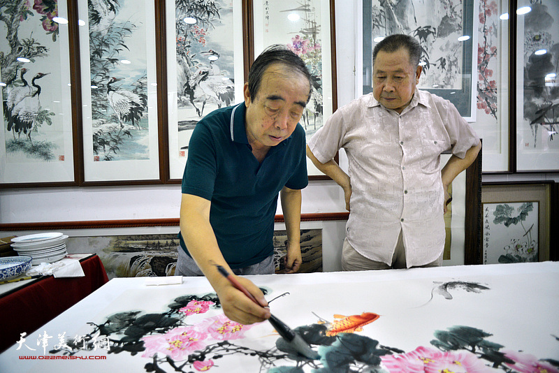 贾春明、武子明在鹤艺轩创作巨幅花鸟画《富贵有余》图。
