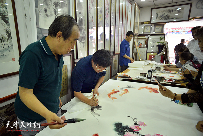 贾春明、李兆河在鹤艺轩创作巨幅花鸟画《富贵有余》图。
