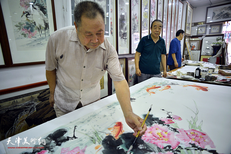 武子明在鹤艺轩创作巨幅花鸟画《富贵有余》图。