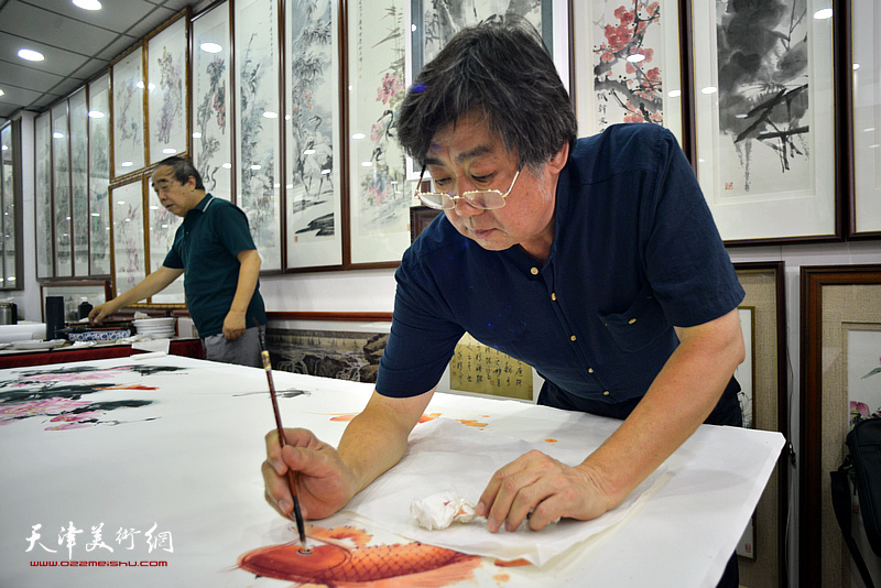 李兆河在鹤艺轩创作巨幅花鸟画《富贵有余》图。
