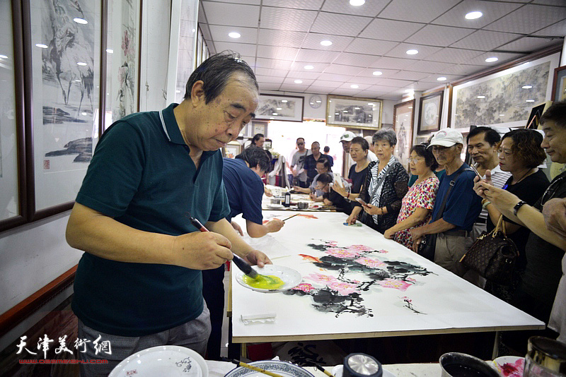 贾春明在鹤艺轩创作巨幅花鸟画《富贵有余》图。