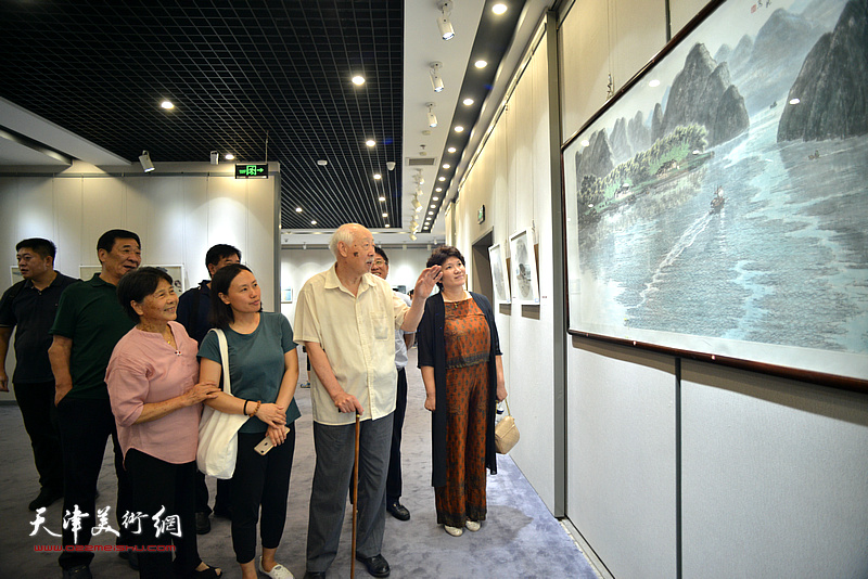 周志龙在画展现场为观众讲解展品。