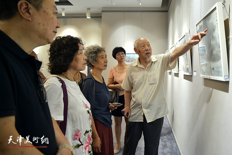 周志龙在画展现场为观众讲解展品。