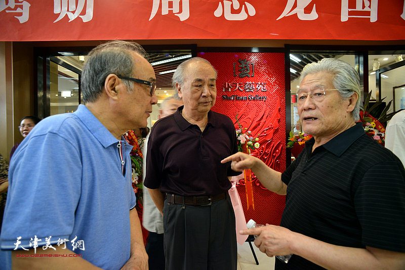王鸿勋与郭书仁、王振德在画展现场交流。