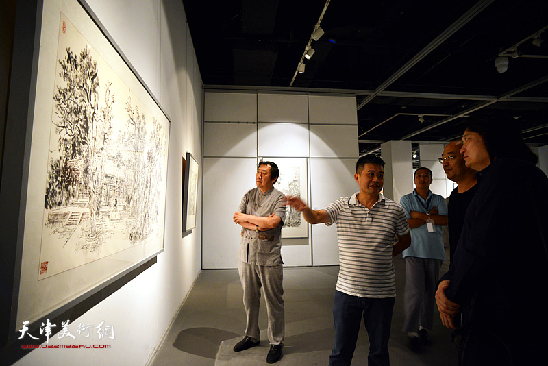 厦门市张仃美术馆馆长蔡向前在展览现场介绍展出的张仃作品。