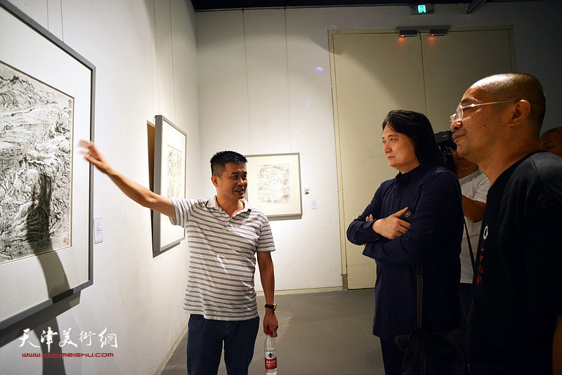 厦门市张仃美术馆馆长蔡向前在展览现场介绍展出的张仃作品。