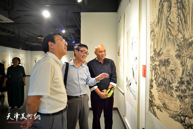 黑成义向刘志凯介绍展出的作品。