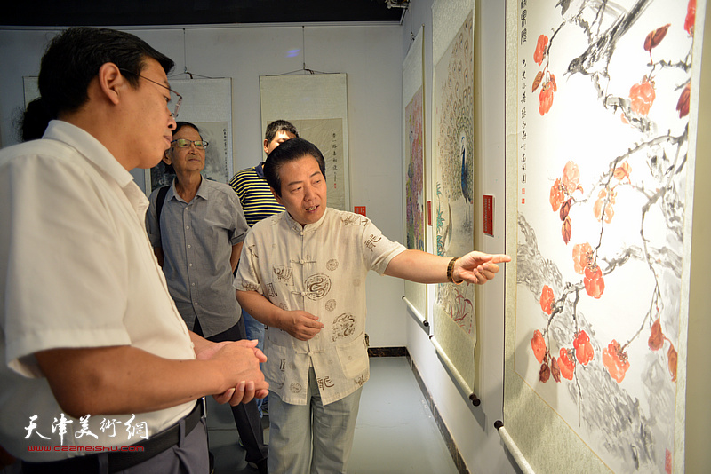 李锐钧向刘志凯介绍展出的作品。