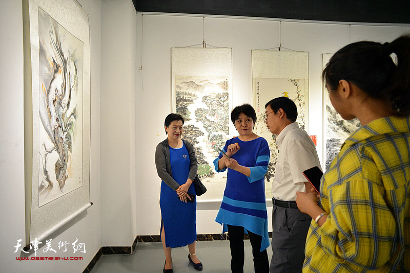 朱红向刘志凯介绍展出的作品。