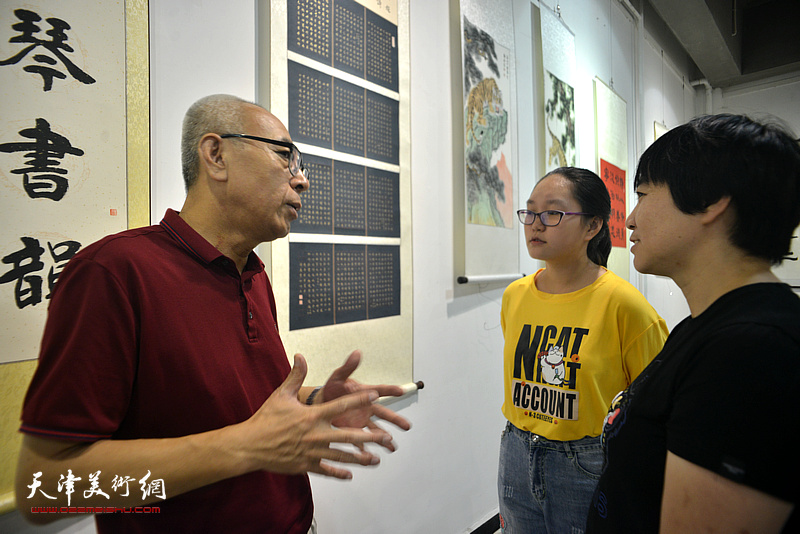 王炳学与书画爱好者在展览现场交流。