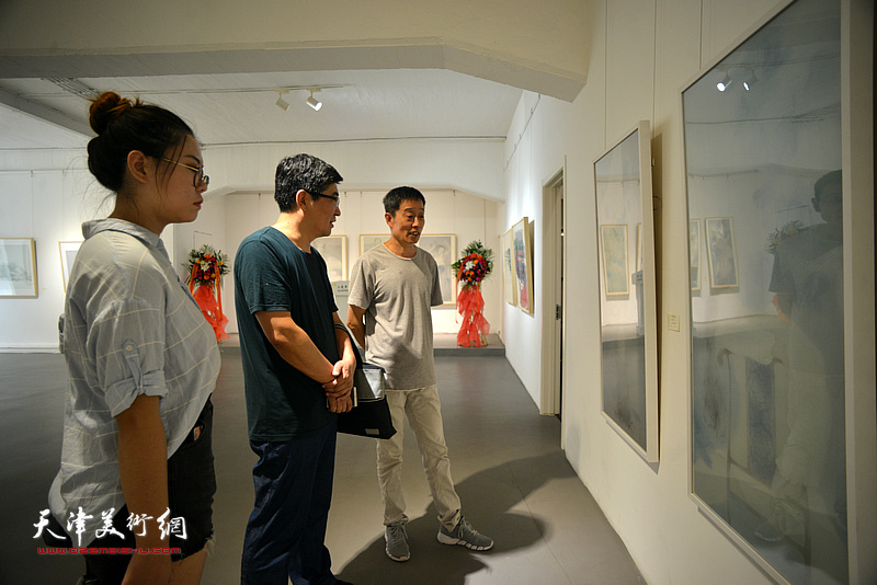 艺术家高玉国教授和来宾观赏展出的作品。