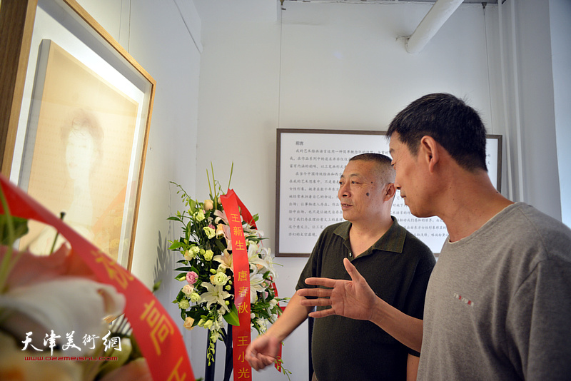 艺术家高玉国教授和来宾观赏展出的作品。