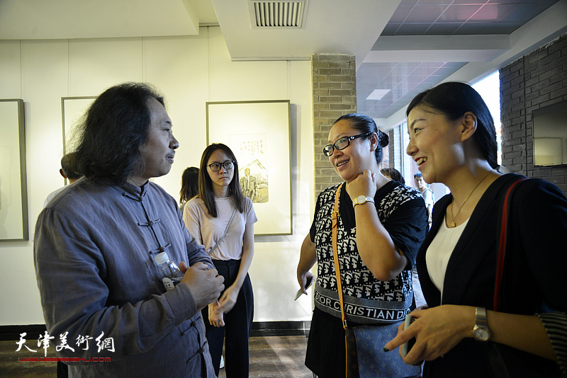 贾广健在画展现场观与观众交流。