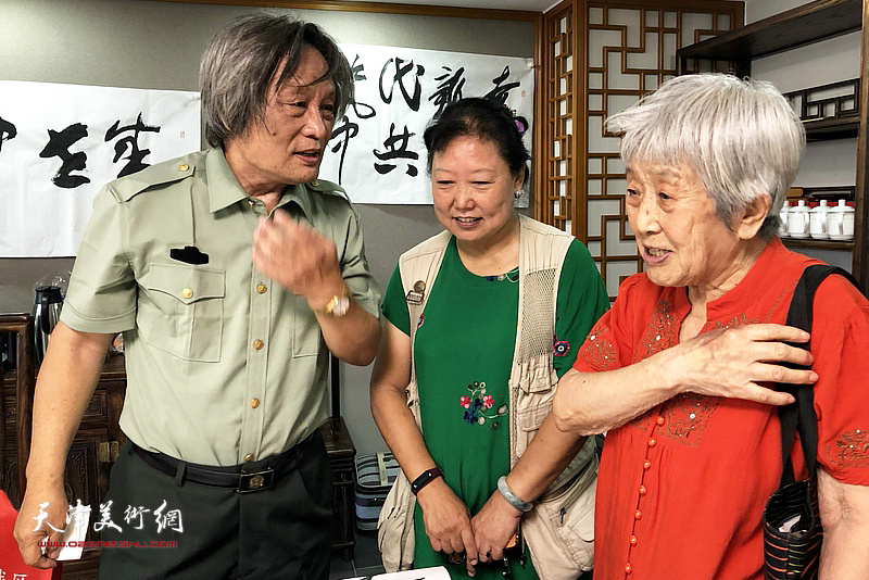 刘乃驹在展览现场与河西军休所书画组交流。