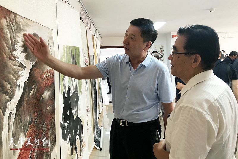 王勇、刘土岭在展览现场观看作品。