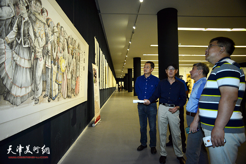 王印强向刘玉森、黑俊志、李欣介绍展出的作品。
