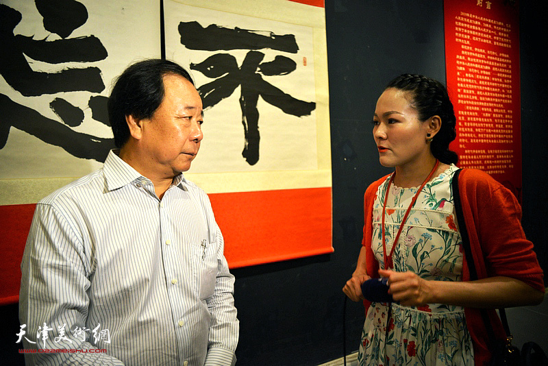 记者齐祺在学习用典书画展现场采访赵寅。