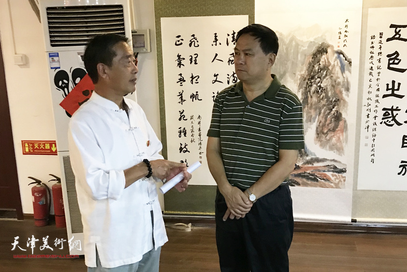 张金锁、李俊杰在书画展现场交流。