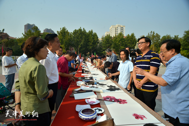 区、街有关领导在书画长卷创作现场与书画家见面交流。