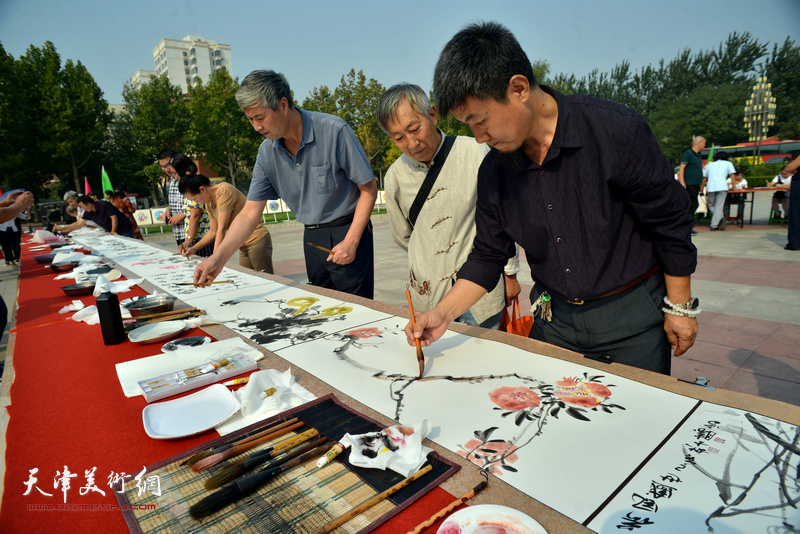 李同、李建新、孙希印在书画长卷创作现场。