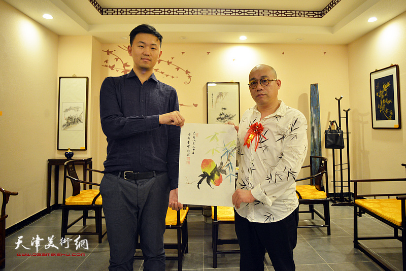 爱新觉罗·恒鑫向“隆祺轩”杨政赠送绘画作品。