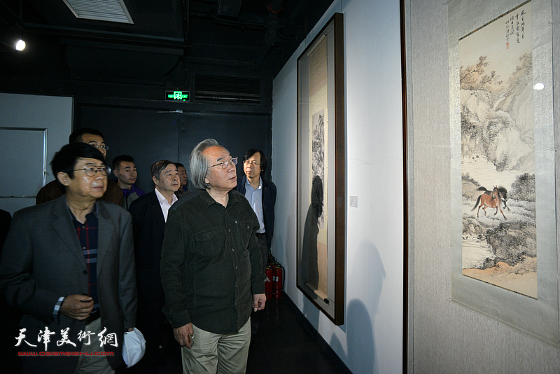 霍春阳、毓峋、毓岳在画展现场观赏展出的作品。