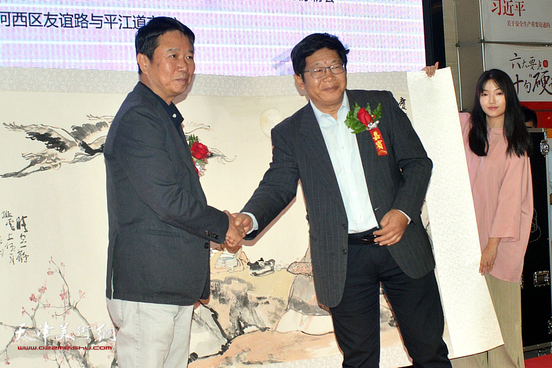 画家代表刘文生将杨德树、陈冬至等人共同合作的作品献给南开大学，许京军副校长接受捐赠。
