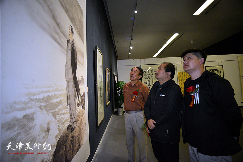 李岳林、陈治、白光观赏展出的画作。