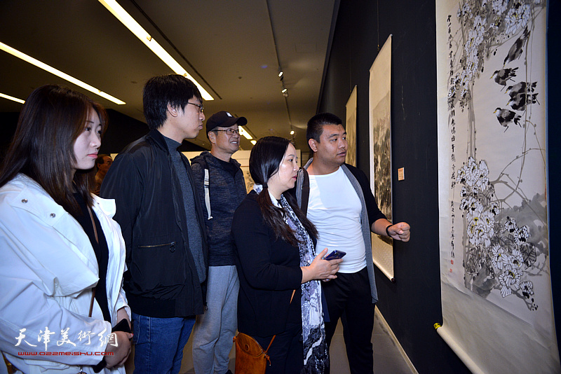 王成功等青年画家观赏展出的画作。