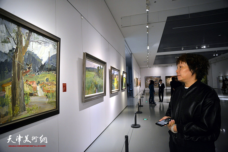 谢红在画展现场观看作品。