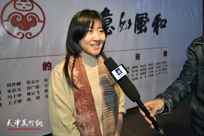 策展人冷艺丹在画展现场接受媒体采访。