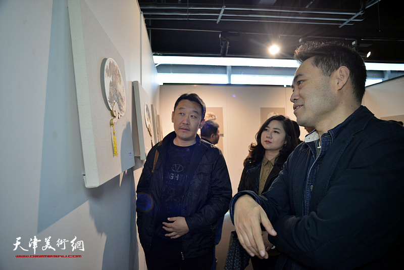 高山、王霞、于健在画展现场观看画作。