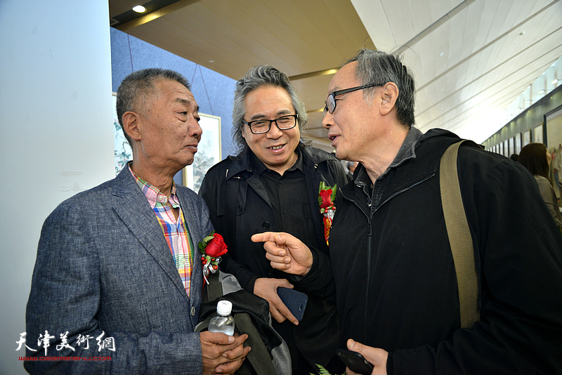 邓国源、陈福春、李军在画展现场交谈。