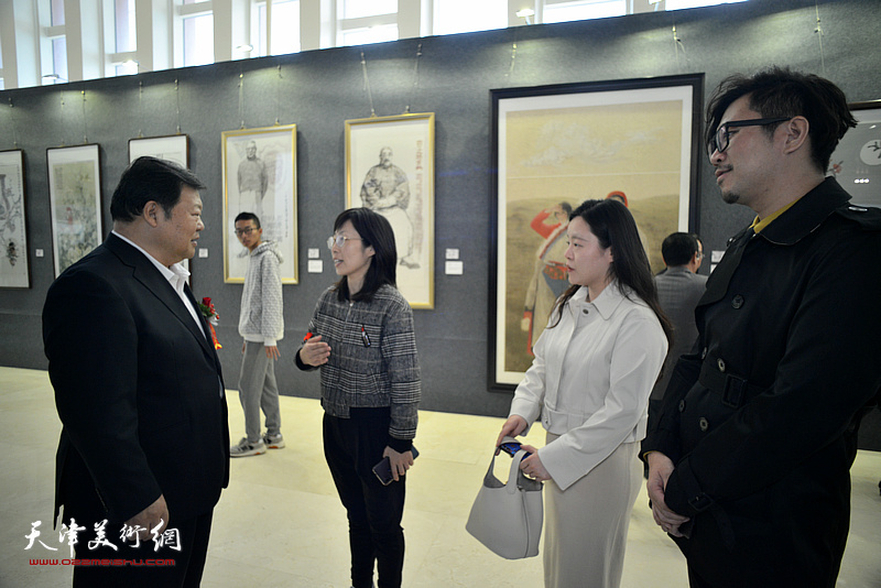 散襄军在画展现场与青年画家陈晨、石秀华、蒯丰交谈。