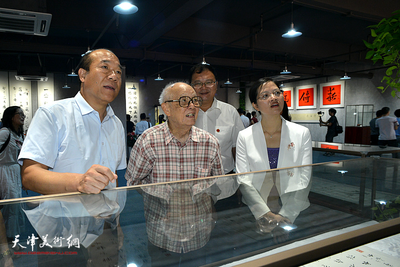 王树秋陪同吴兆奇、黄少兰等嘉宾观赏展出的作品。