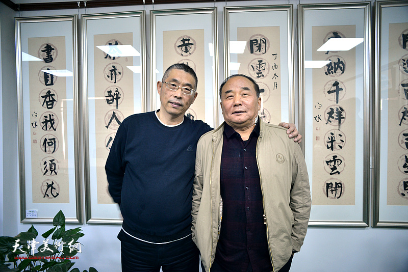 梁学忠、李建华在师生书画作品展现场。