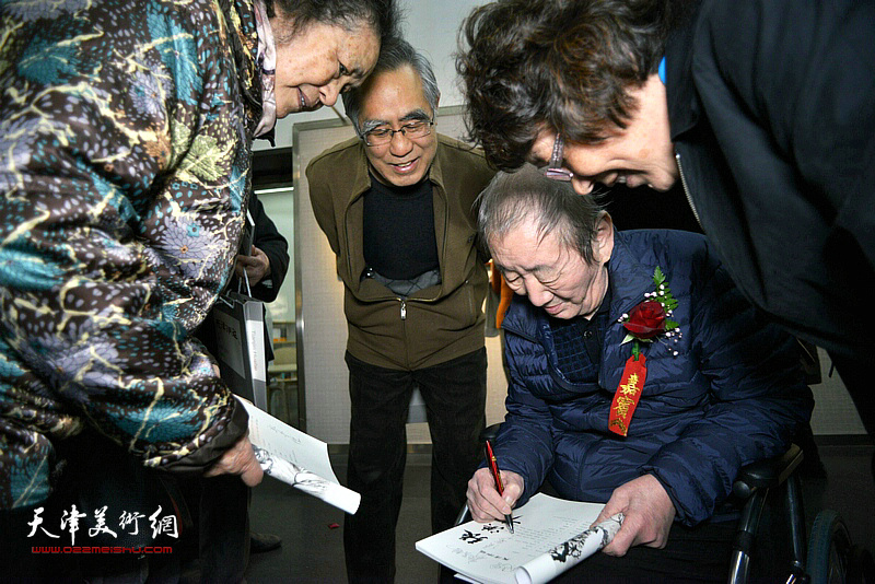 侯春林在画展现场为读者签名。