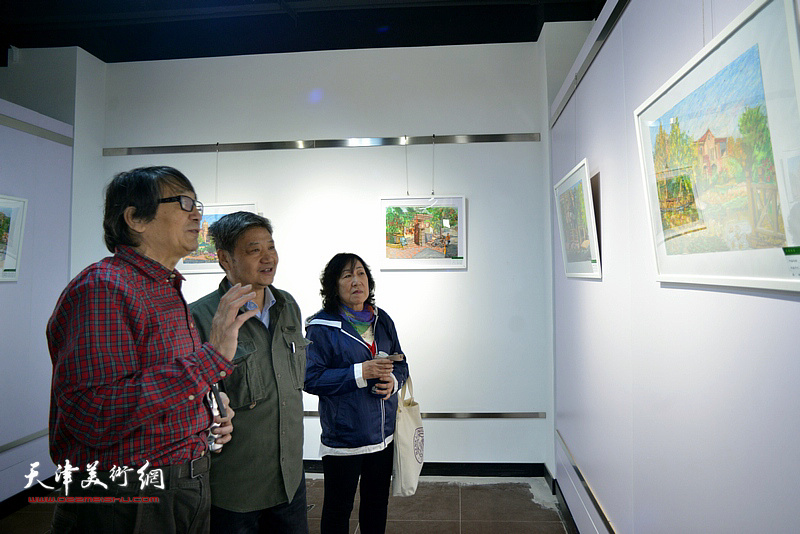 张胜、刘志平、任小楣观赏展出的刘莉莉画作。。