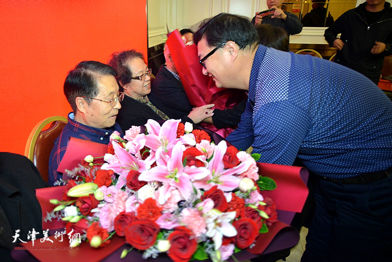 新弟子刘千友向师傅韩文来、师母高照萍敬献鲜花。