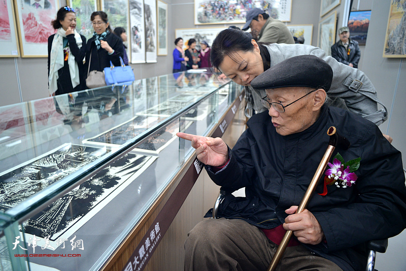 孙长康、王昕在画展现场观看作品。