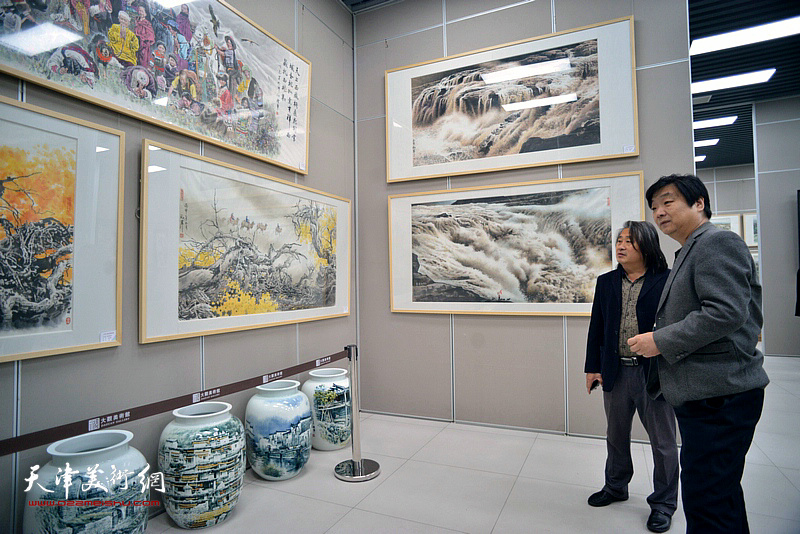 翟洪涛、孙富泉在画展现场观看作品。