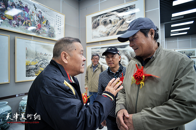 董铁山、季家松在画展现场交谈。