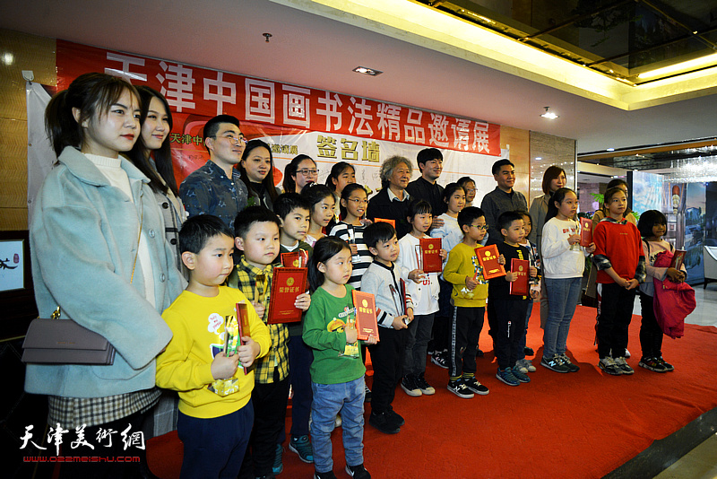 刘向东、高嵩、程从礼、宋妍婧与获奖的小画家在画展现场。