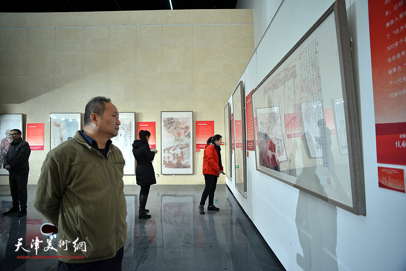 陈子文在画展现场观看作品。