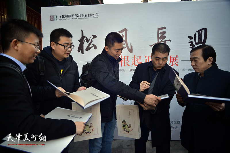 张根起为来宾在《松风长迴——张根起近作展作品集》上签名留念。