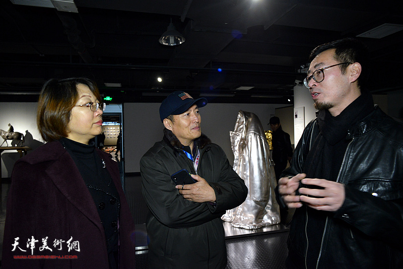 参展作者赵展向孙杰、王学斌介绍展出的作品。