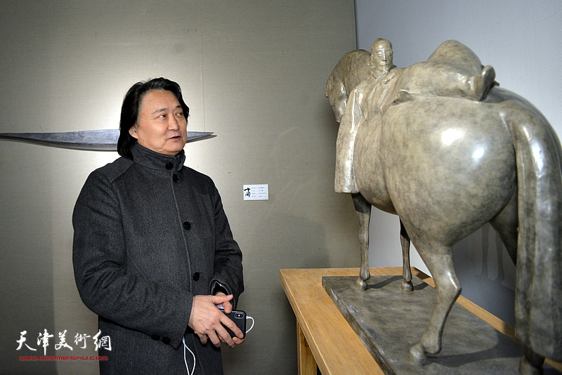 薛义在展览现场观看作品。