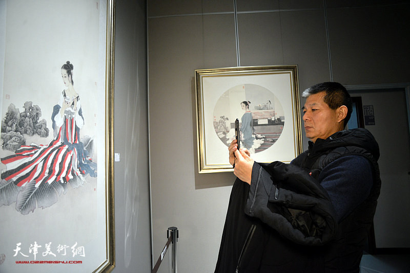 范扬在画展现场观赏展出的作品。