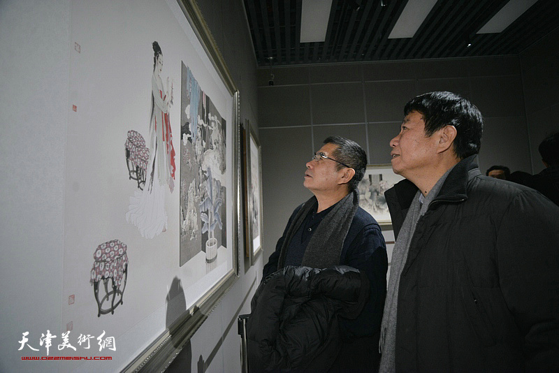 杨佩璋、刘文生在画展现场观赏展出的作品。